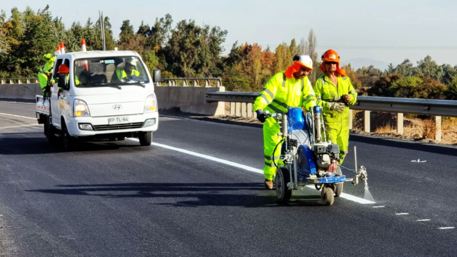 Trabajadores en una carretera pintan las lineas de una de las pistas